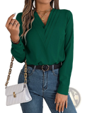 Emerald green long-sleeved blouse with v-neck and pleated front styled as white satin v neck wrap blouse with black trim