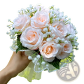 White silk rose wedding bouquet featuring delicate peach artificial roses with baby’s breath and beaded lace ribbon wrapping
