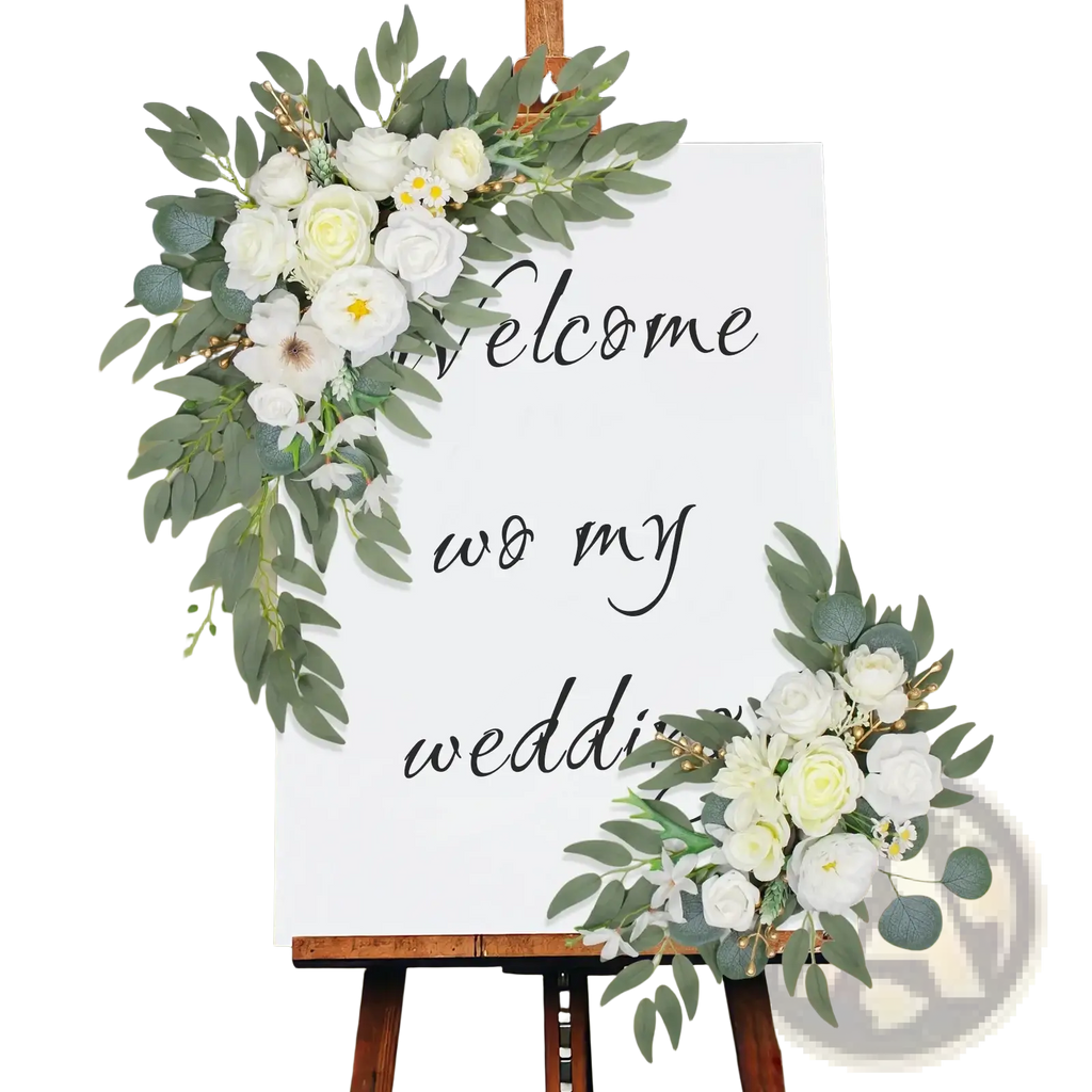 A white wedding arch sign with artificial greenery and white flowers for welcome to my wedding decor