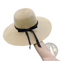 Beige wide brim straw sun hat with a black ribbon bow designed for sun protection and style
