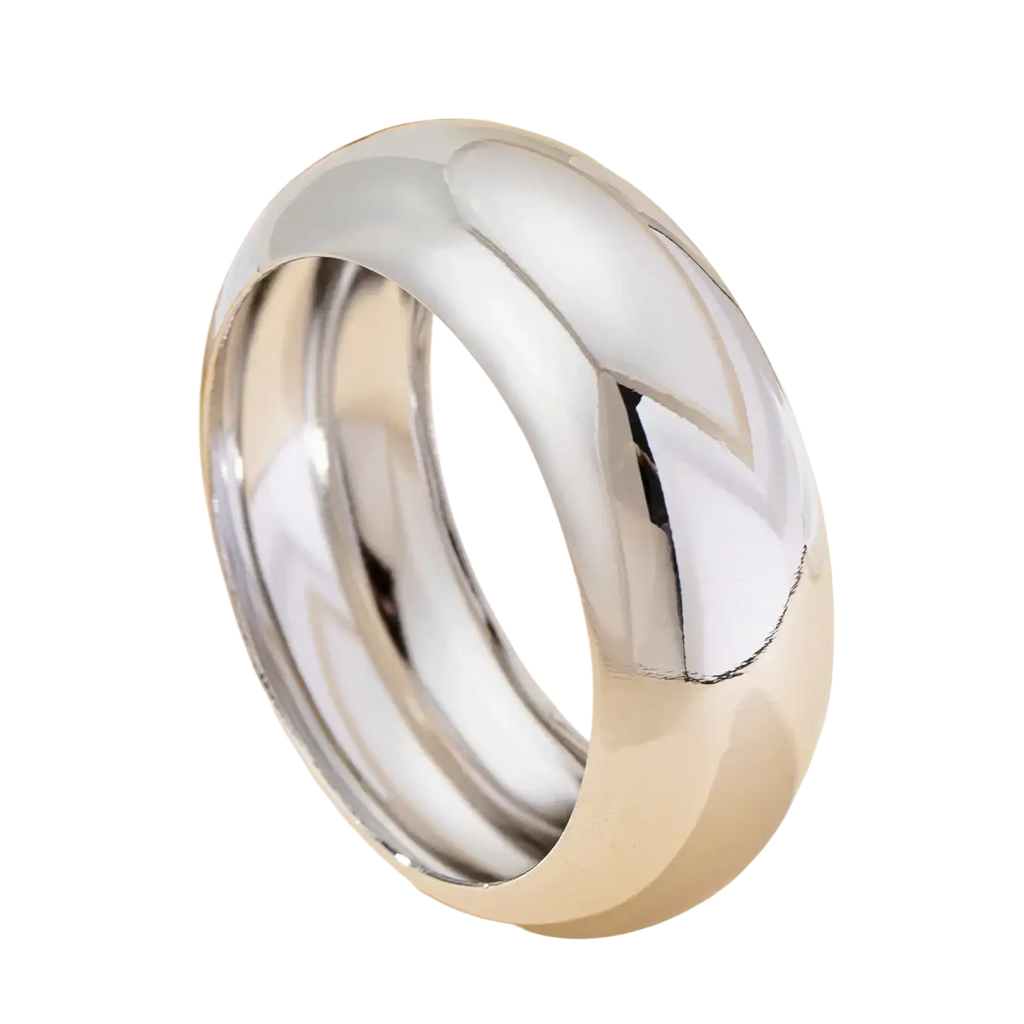 A polished silver band ring with a smooth rounded design and reflective surface, shown with a wide gold bangle bracelet