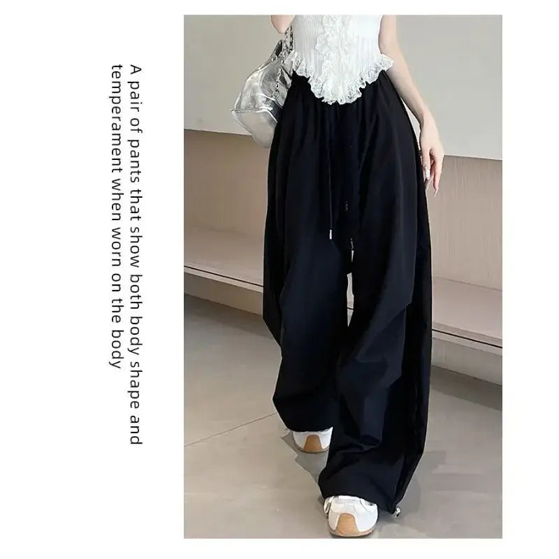 Black wide leg pants with elastic waist and lace side panels featuring a relaxed flowing silhouette