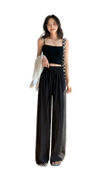 Black wide leg pleated trousers for women with relaxed flowing fabric and elastic waistband ideal for summer wear