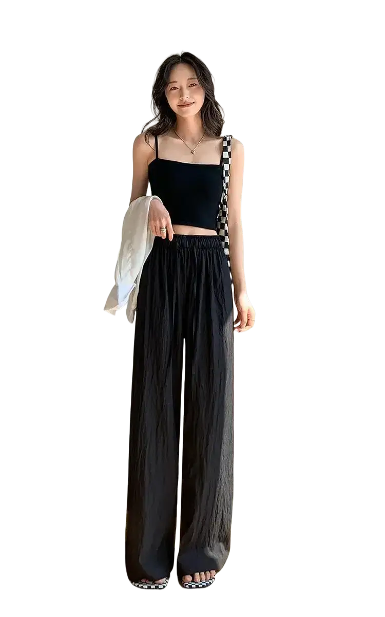 Black wide leg pleated trousers for women with relaxed flowing fabric and elastic waistband ideal for summer wear