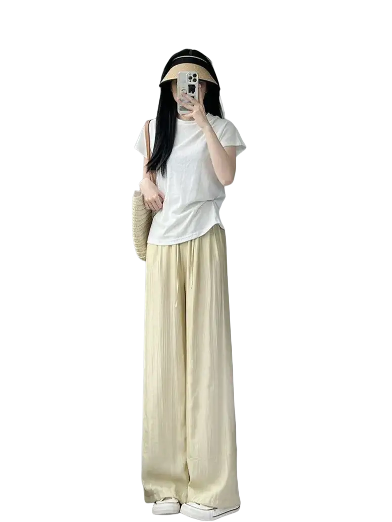 A pair of wide leg pale yellow pleated trousers with flowing drape and soft fabric for summer wear