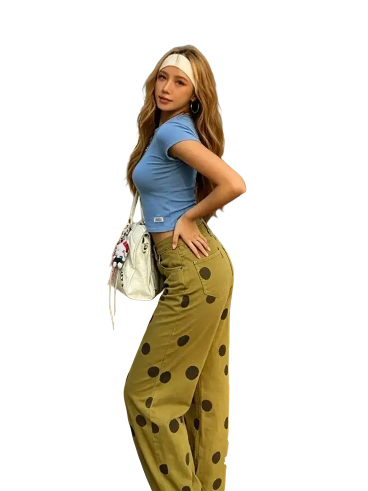 White crossbody bag with playful cartoon charm and adjustable strap paired with wide leg olive green pants