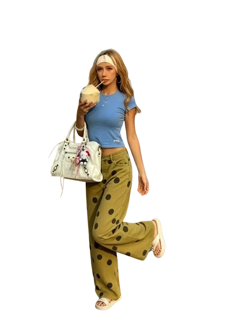 White leather handbag with playful cartoon charms paired with olive green wide leg polka dot high waist pants