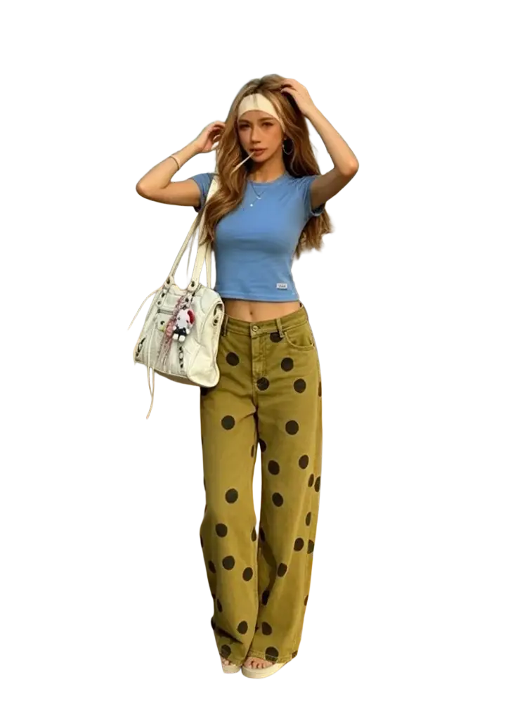 White shoulder bag with black polka dots and plush charm paired with wide leg olive green high waist pants