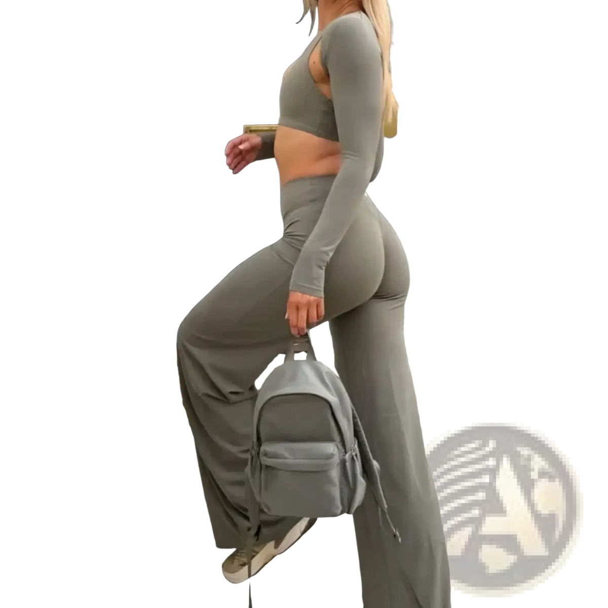 Gray fabric backpack with front pocket and adjustable straps shown from the back side next to wide leg workout leggings