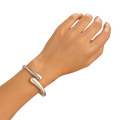 Silver color chunky wide metal bangle with smooth teardrop-shaped curves in an open cuff bracelet design