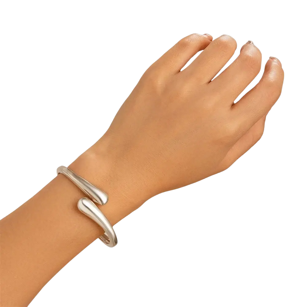 Silver color chunky wide metal bangle with smooth teardrop-shaped curves in an open cuff bracelet design