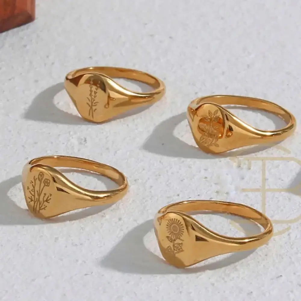 Wildflower engraved gold signet ring set featuring botanical designs on polished gold bands