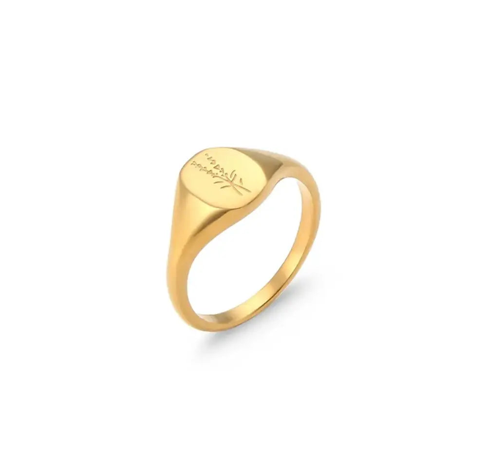 Gold signet ring with a smooth oval face engraved with delicate leaf and text details from wildflower set