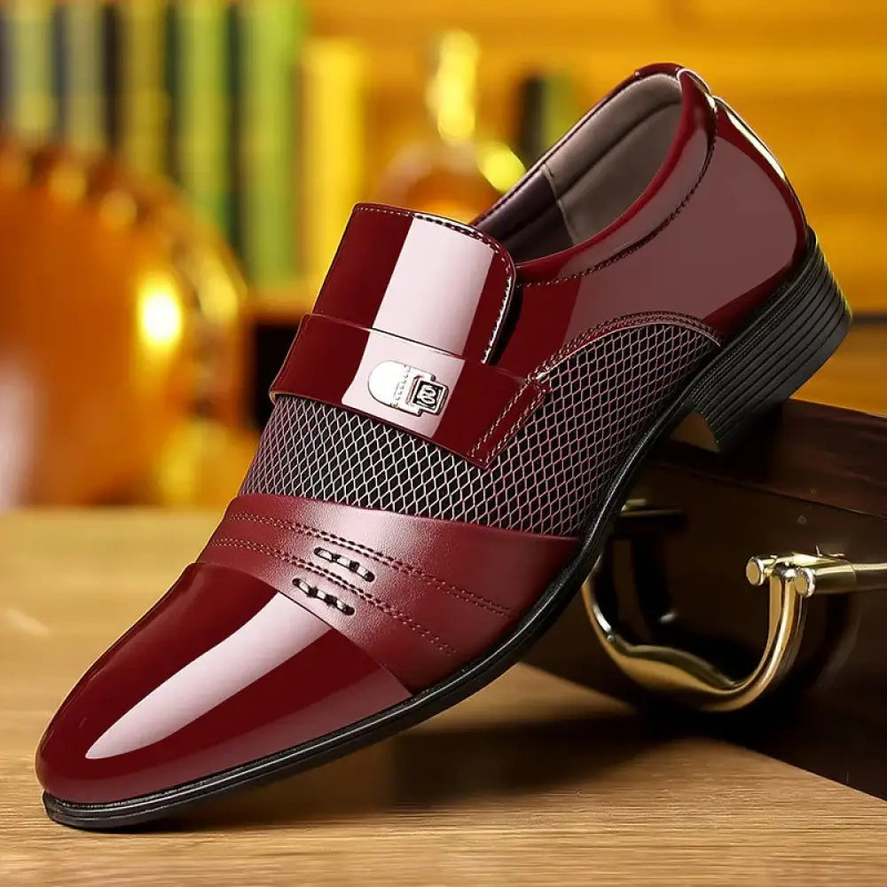 Shiny burgundy patent leather men’s dress shoe with mesh panel and silver buckle for formal wear