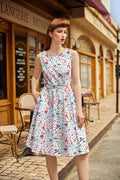 A woman wears a sleeveless knee-length winter cheer vintage 1950s cotton Christmas dress with colorful kitchen utensils