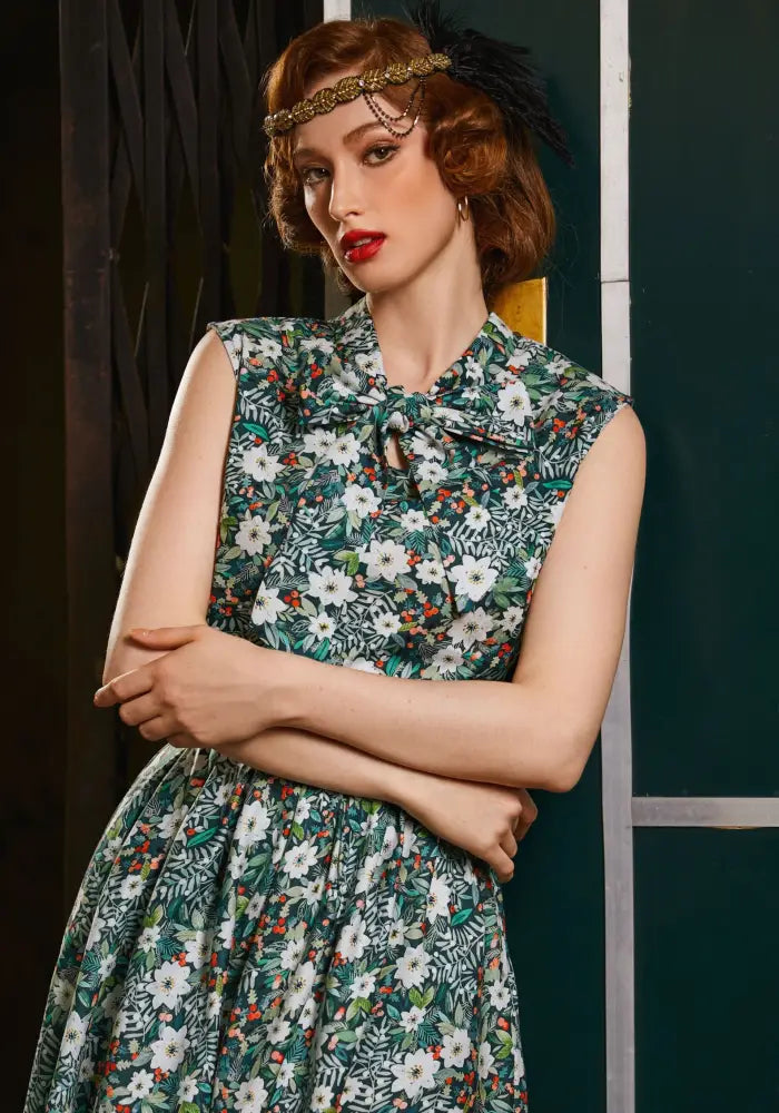 Winter floral sleeveless cotton bow blouse in green with fitted bodice and floral pattern for vintage-inspired style