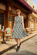 A woman walking down a cobblestone street wearing a vintage-style green floral print sleeveless cotton midi dress with pockets