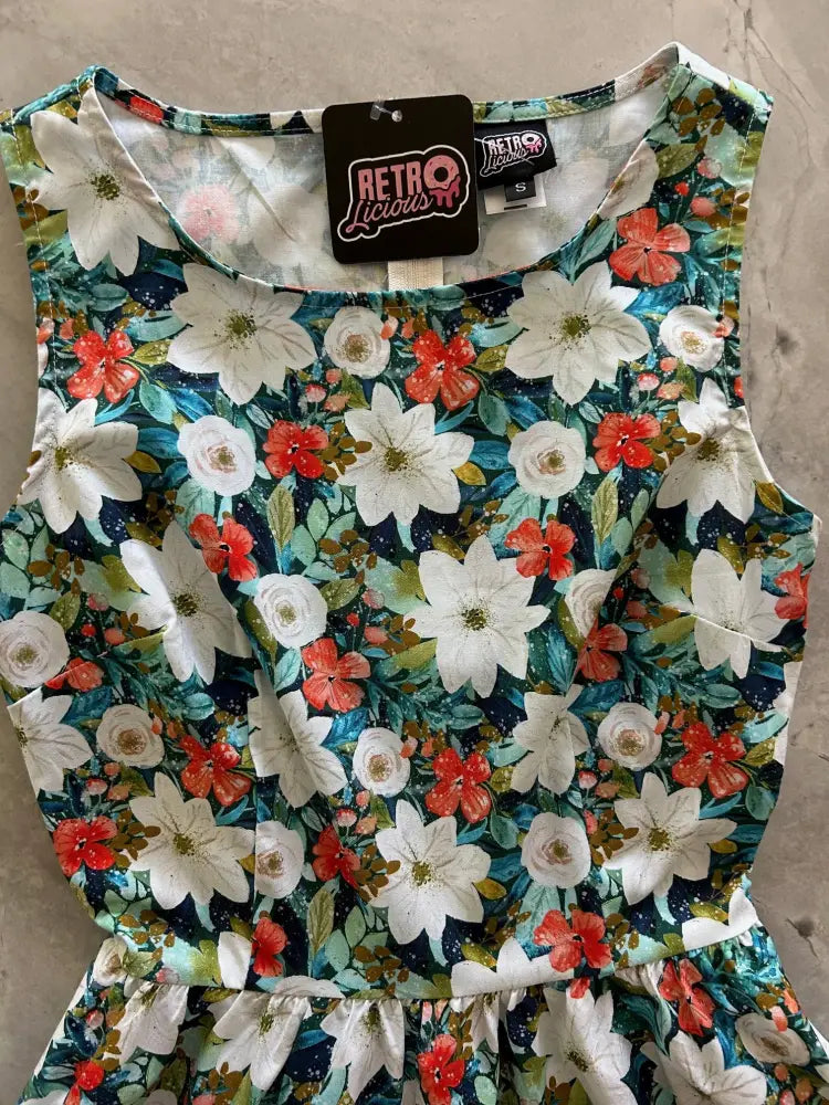Sleeveless cotton midi dress with vibrant white red and teal floral pattern on dark background and pockets