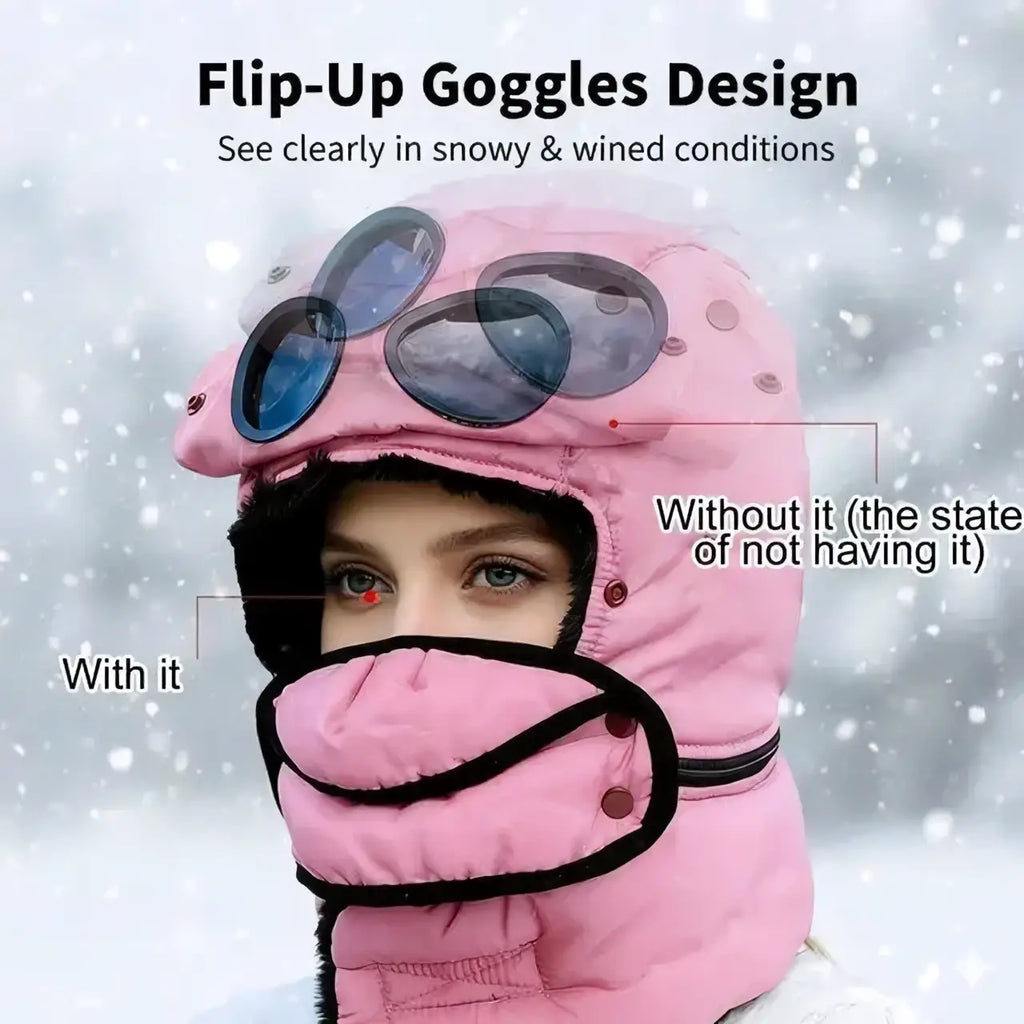 Pink quilted winter hat with black trim trapper style featuring flip-up goggles and integrated face mask for cold weather