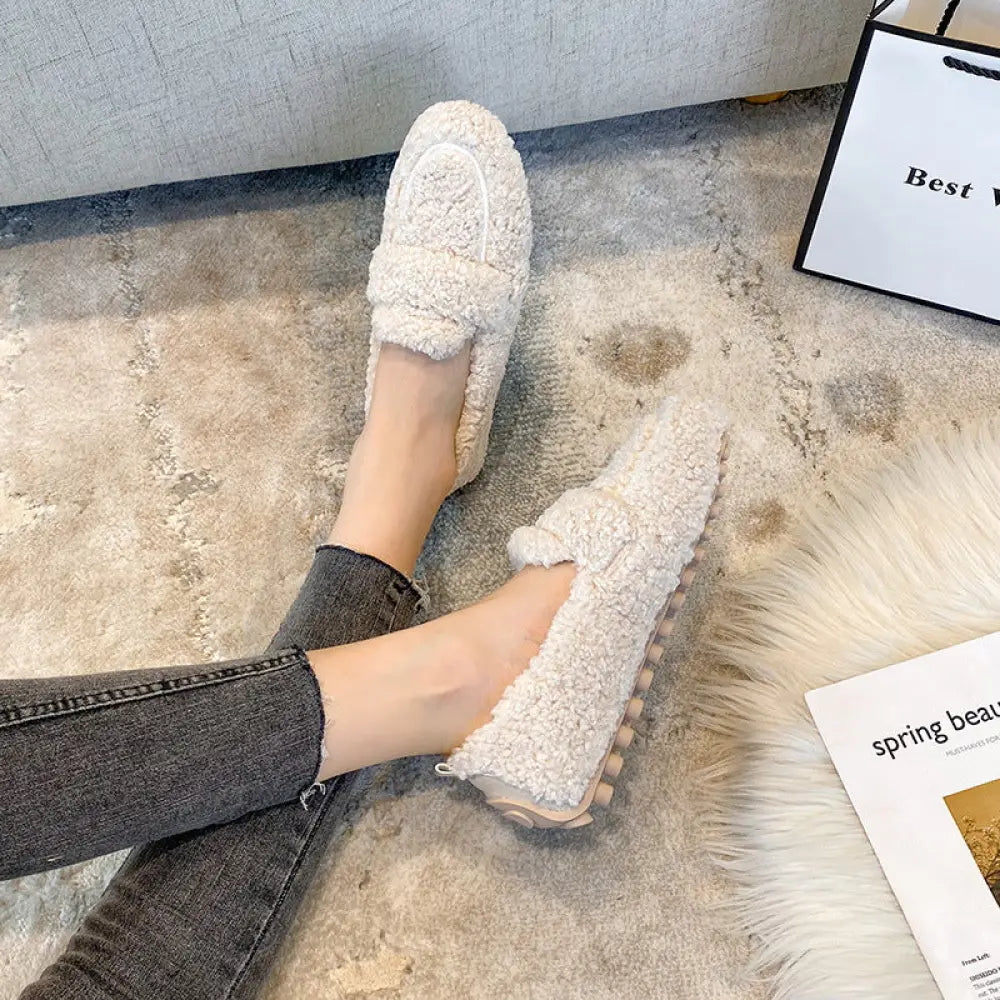 Cream-colored plush faux shearling winter loafers with textured upper and chunky rubber sole for cold weather use