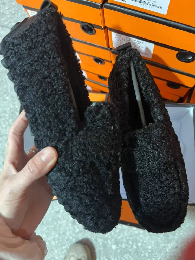 Black plush faux shearling slip-on winter loafers with a fuzzy textured surface and chunky sole