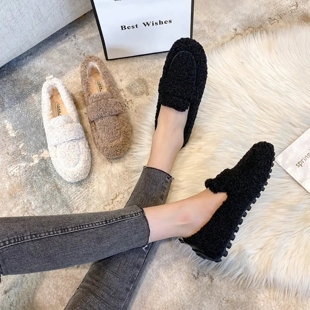 Black plush faux shearling winter loafers with textured upper and chunky rubber sole shown from back side