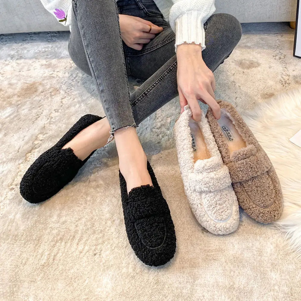 Plush faux shearling winter loafers in black and beige with soft textured exterior and chunky sole for warmth and comfort