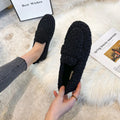 Black plush faux shearling winter loafers with fuzzy textured surface and soft interior lining for cold weather use