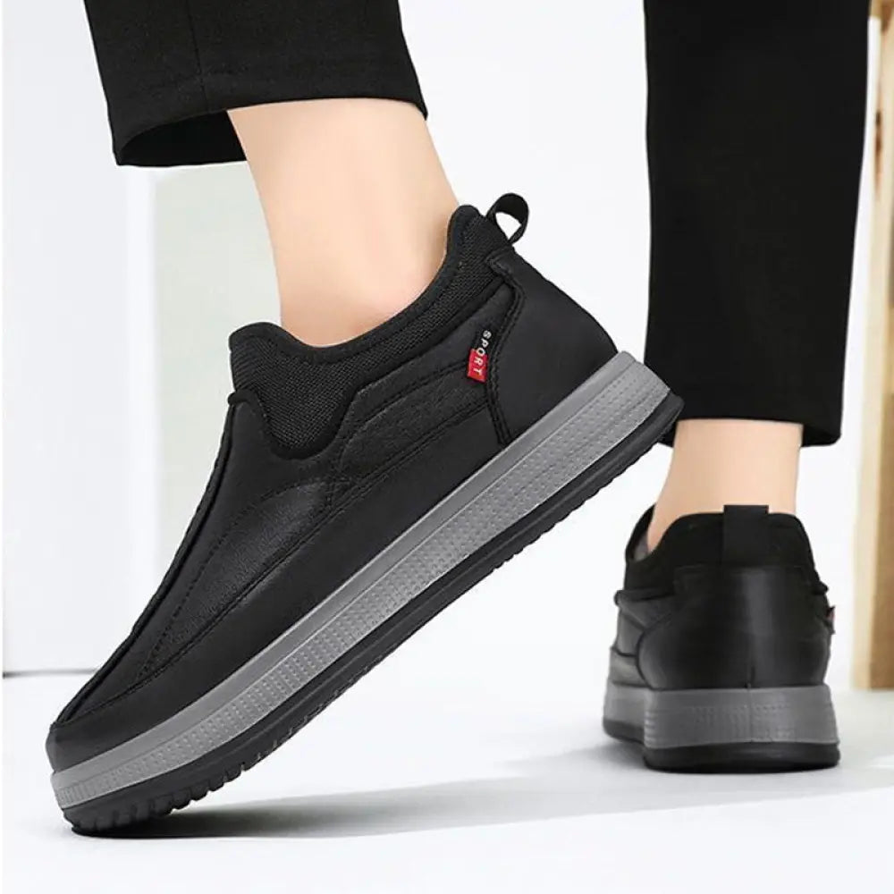 Men’s fleece lined slip on winter snow boot in black with gray rubber sole and breathable mesh upper