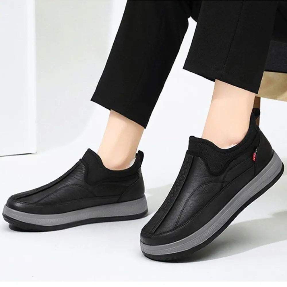 Men’s fleece lined slip on winter snow boots in black with thick cushioned sole and subtle stitching details