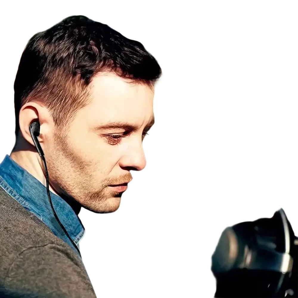 Black in-ear wired headphones with 3.5mm jack and thin wire worn by man while driving for mp3 mp4 use