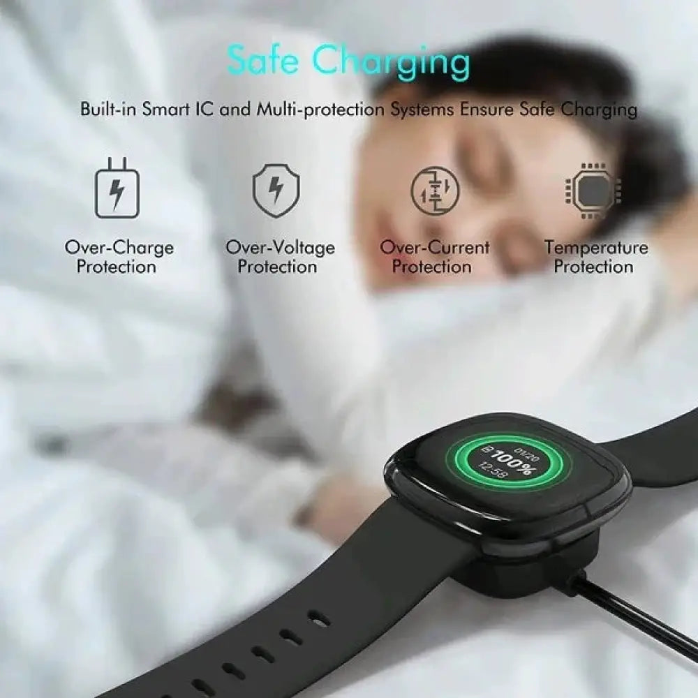Black Fitbit Sense and Versa 3 4 smartwatch with circular digital display showing 100% charge connected to magnetic USB fast charging dock