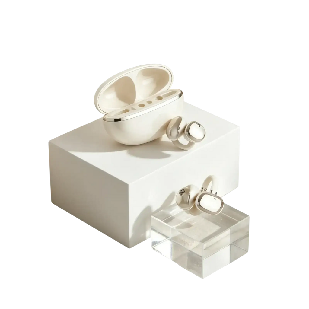 Cream-colored wireless ear clip bluetooth headphones with silver accents resting in a matching charging case