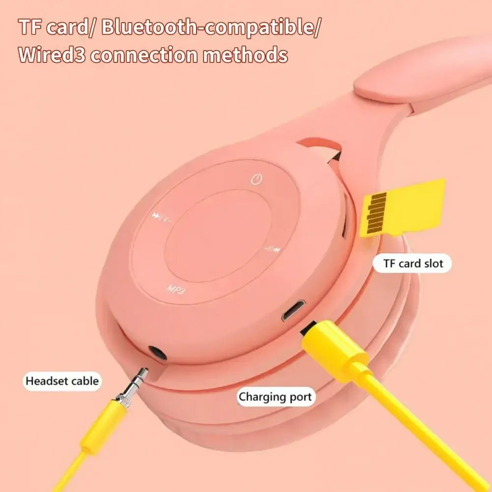 Pink wireless over ear bluetooth headphones with tf card slot charging port and yellow 3.5mm audio cable for wired use