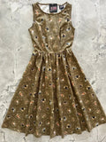 Sleeveless olive green cotton midi dress with subtle sheen and cartoonish birds pattern featuring pockets