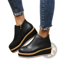 Women ankle boots made of black leather with chunky platform wedge sole featuring tan and white accents