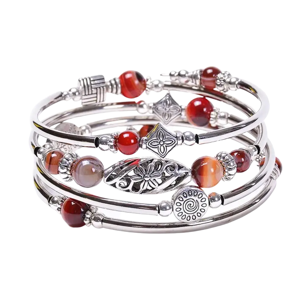 Stacked silver women bangle featuring natural stones, red and orange gemstones, charms, and small spherical beads