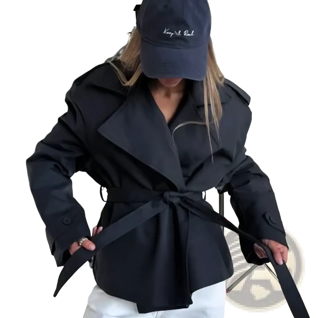 Black belted trench coat with structured collar and shoulder pads offering casual chic outerwear for women
