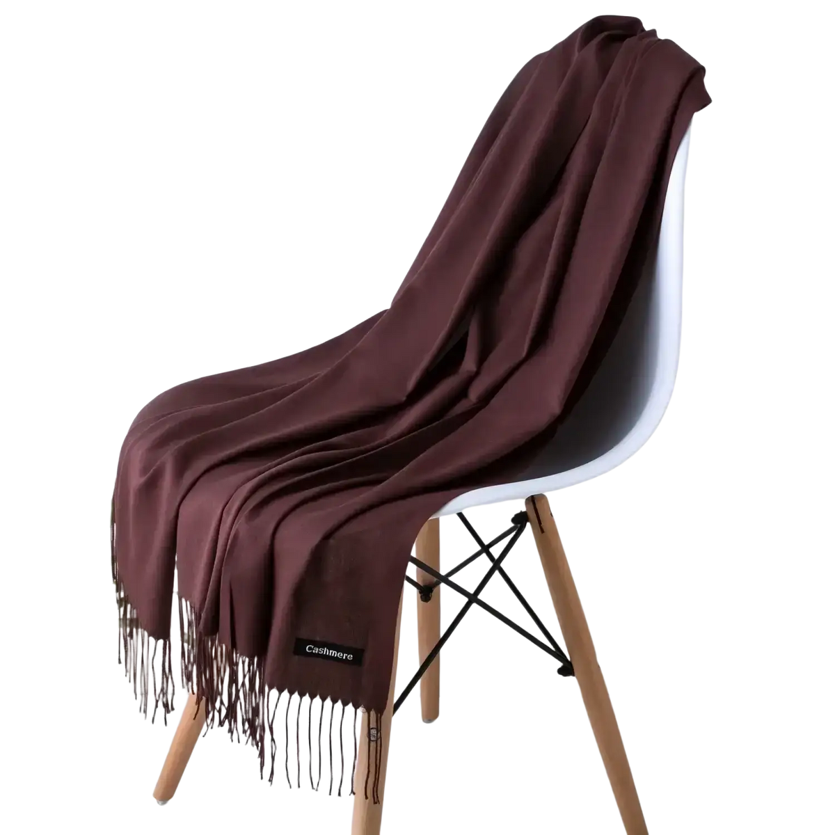 A rich burgundy cashmere feel winter scarf with delicate fringe elegantly draped over a modern white chair