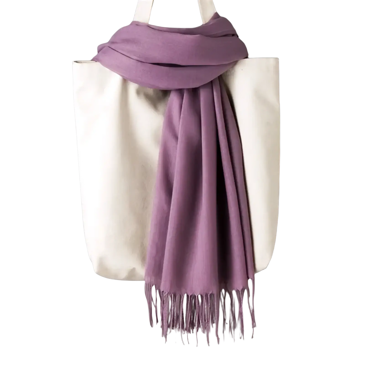 A soft lavender cashmere feel winter scarf shawl with delicate fringe draped over a white tote bag