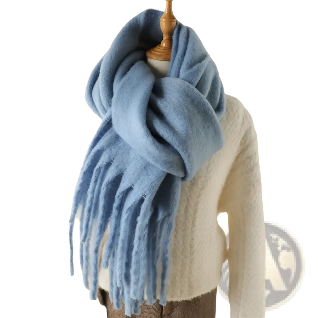 A soft light blue cashmere feel winter scarf shawl with long fringed ends draped around a mannequin