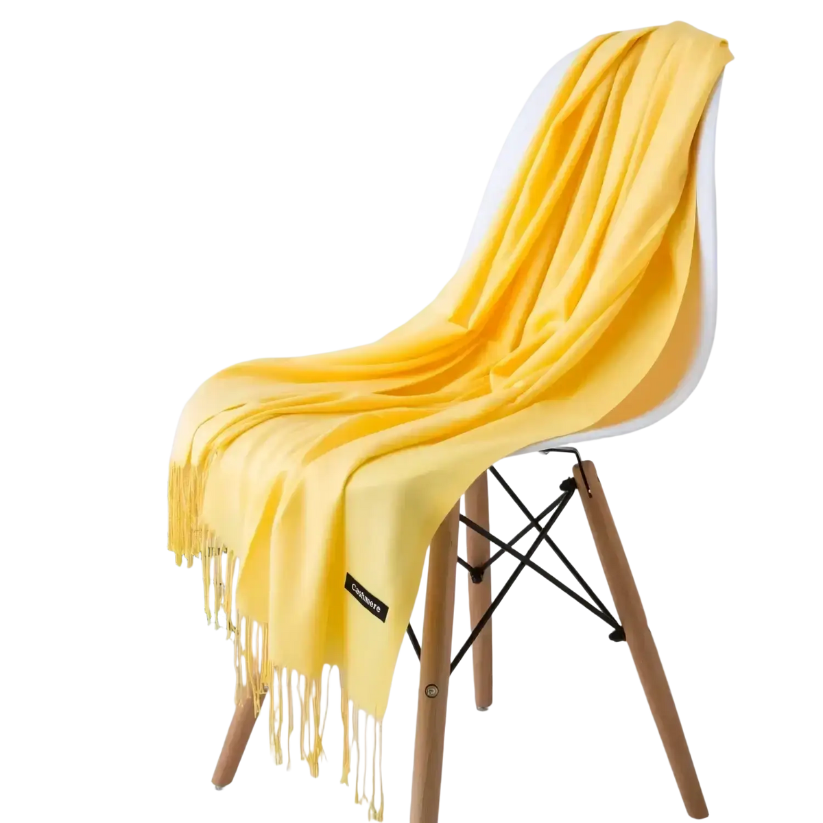 A soft vibrant yellow cashmere feel winter scarf with delicate fringe drapes elegantly over a modern chair