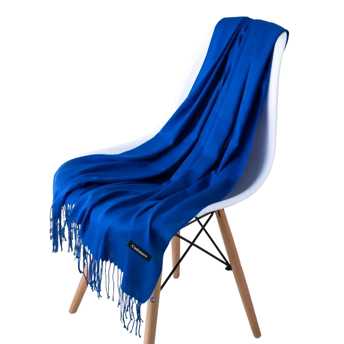 A vibrant royal blue cashmere feel winter scarf with delicate fringe elegantly draped over a modern white chair