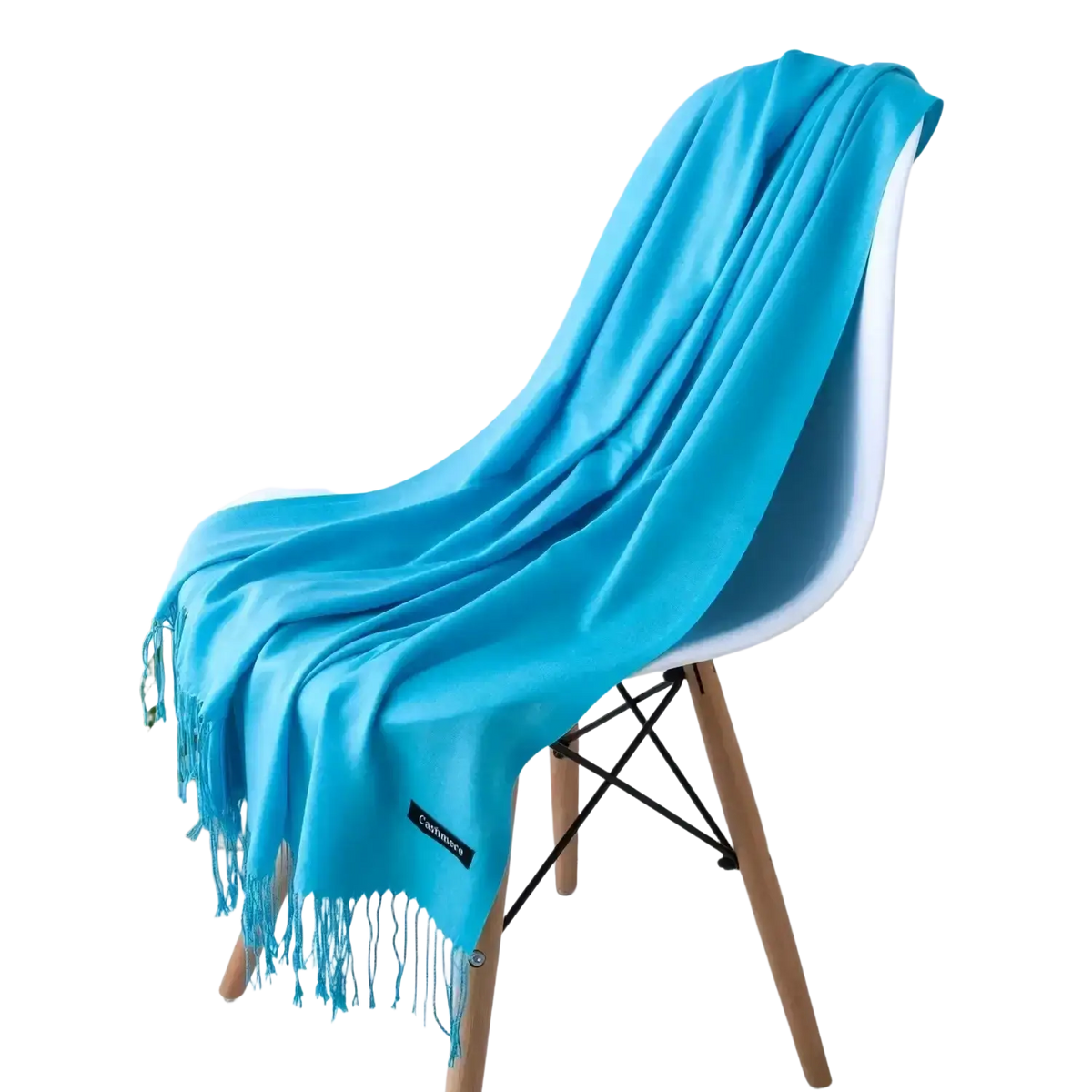 A vibrant turquoise cashmere feel winter scarf with delicate fringe elegantly draped over a modern chair