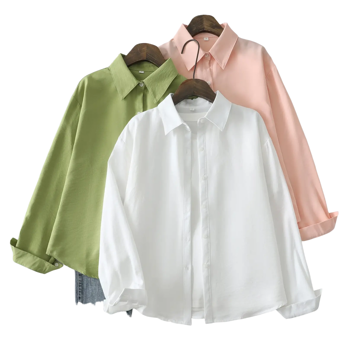 Three cotton blend long sleeve casual blouses in white sage green and blush pink hang on wooden hangers