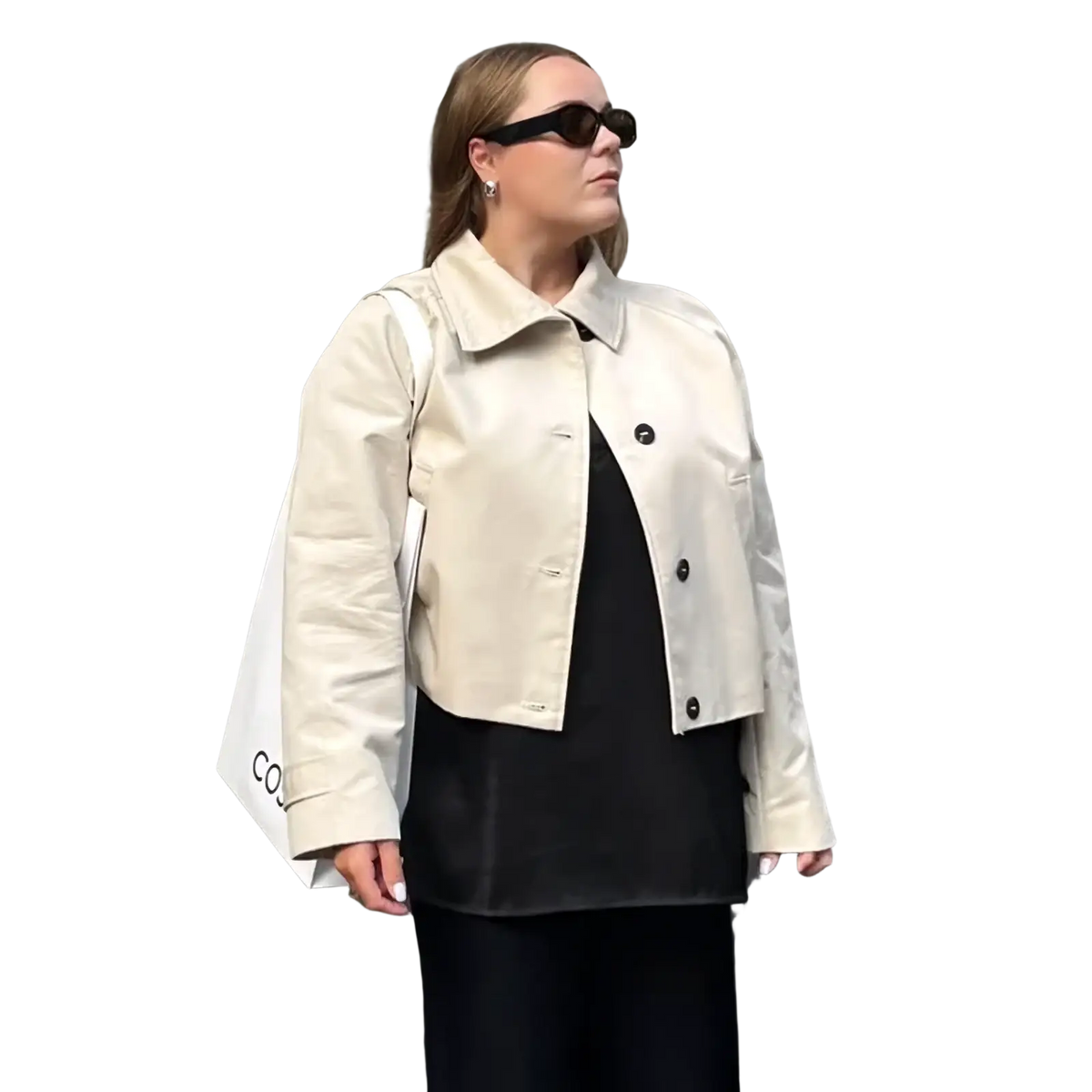 Beige cropped trench coat for women featuring black buttons and a structured collar in a short windbreaker style