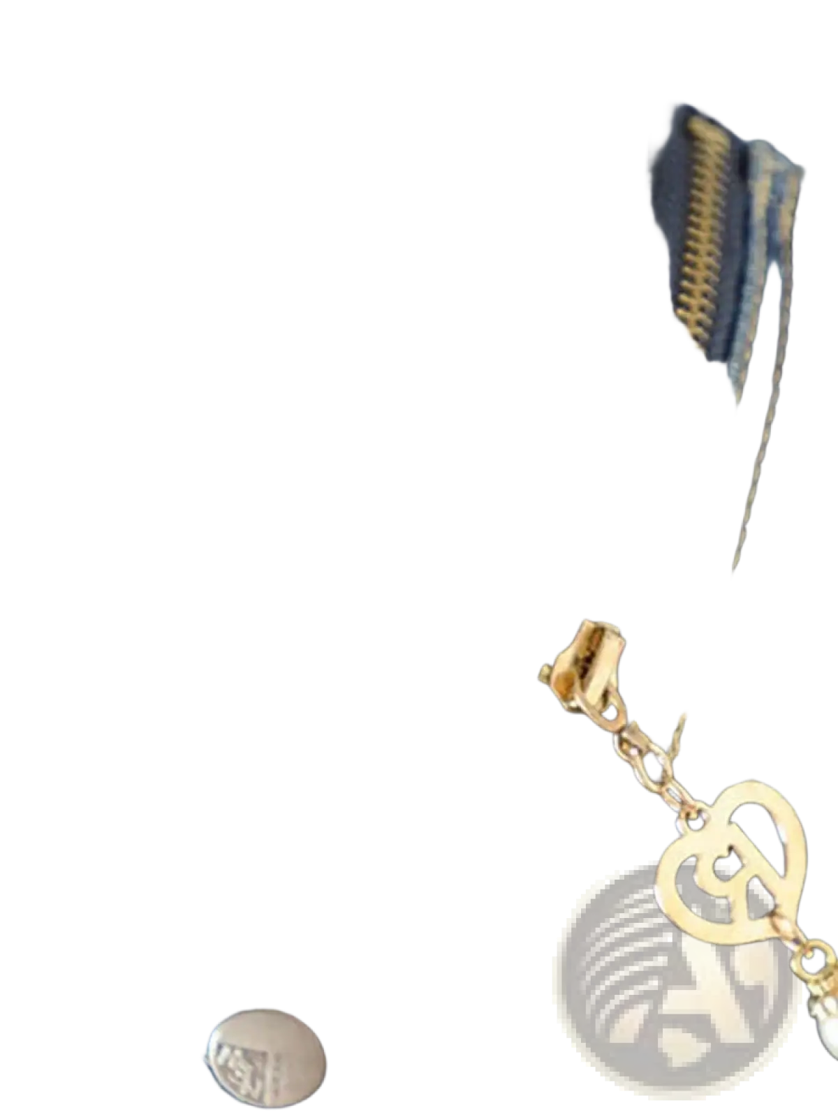 Gold-toned heart-shaped zipper pull with chain on women denim vest jacket casual sleeveless outerwear against dark blue denim