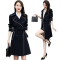 Women double breasted trench coat in black with white contrast stitching and a belted waist for stylish outerwear
