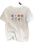 White short sleeve t shirt for women with colorful embroidered daisies in blue white yellow and pink on the front