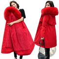 Vibrant red women fur hooded winter parka with plush fur-lined hood and quilted long padded coat front view